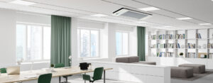 Modern office space with a ceiling-mounted hisoair air purifier, green curtains, white shelves, and minimalist furniture.