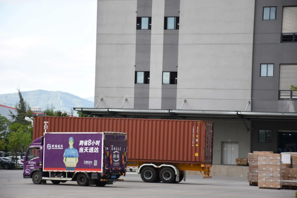 Truck and shipping container at the loading dock of the warehouse.